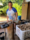 Produtora quebrando castanha de baru